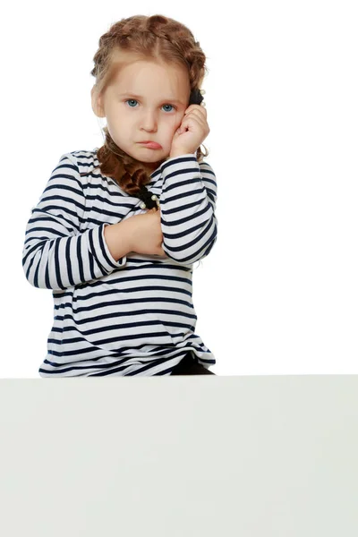 Una bambina sta guardando da dietro uno striscione vuoto. — Foto Stock