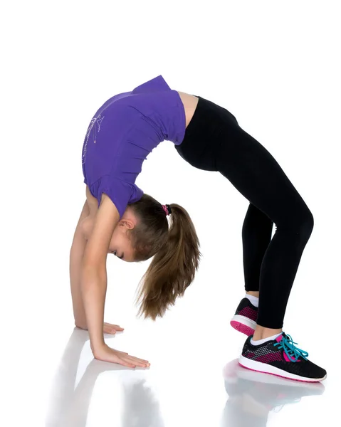 The little gymnast performs a bridge. — Stock Photo, Image