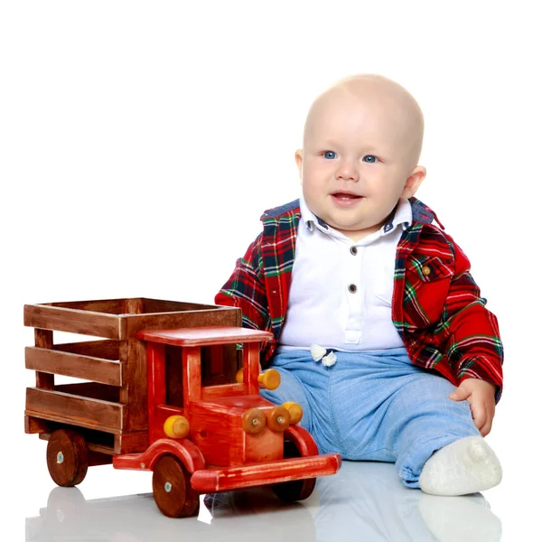 A little boy is playing with a toy car. — Stock Photo, Image