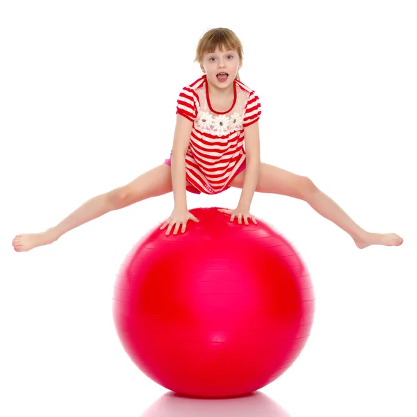 Una niña está saltando en la gran pelota de gimnasia . — Foto de Stock