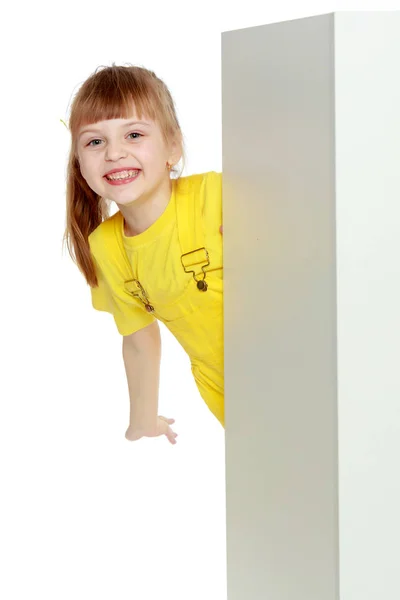 Lány egy rövid frufru a fej és a világos sárga overall. — Stock Fotó