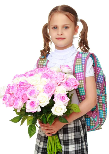 Kleines Schulmädchen mit Blumen — Stockfoto