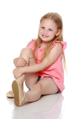 Küçük kız yerde oturuyor..