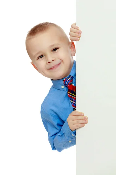 Pojke kikar ut från bakom banderollen — Stockfoto