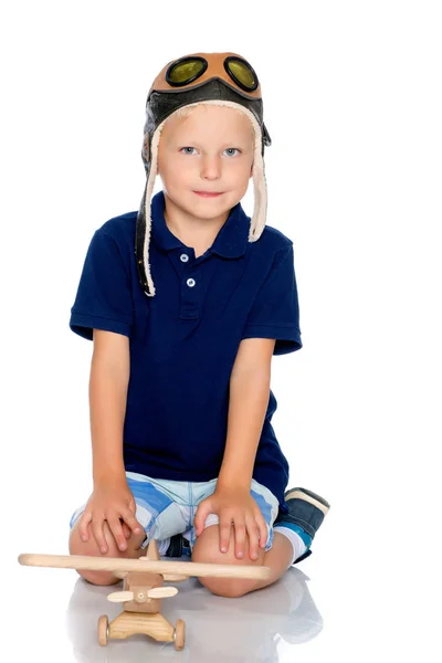 Niño pequeño con un avión de madera . — Foto de Stock