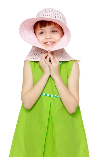 Ein Mädchen posiert mit einem Strohhut am Strand. — Stockfoto