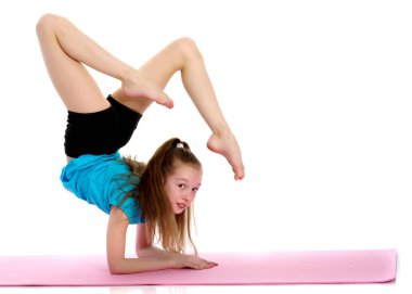 Bir jimnastikçi kollarının önünde egzersiz yapar..