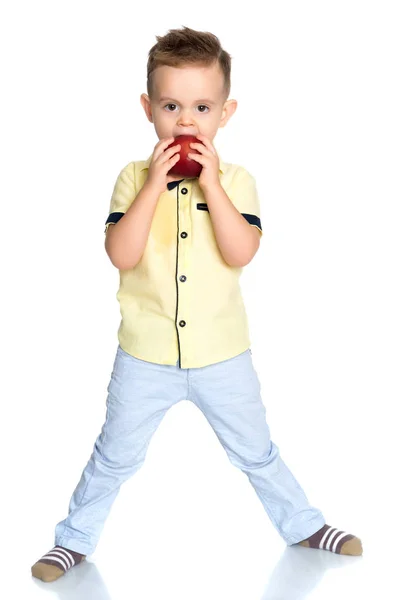 Den lilla pojken tar en tugga av ett äpple. — Stockfoto