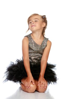 Küçük kız yerde oturuyor..