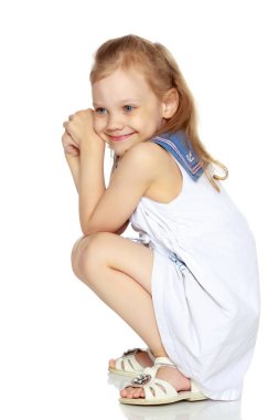 Küçük kız yerde oturuyor..