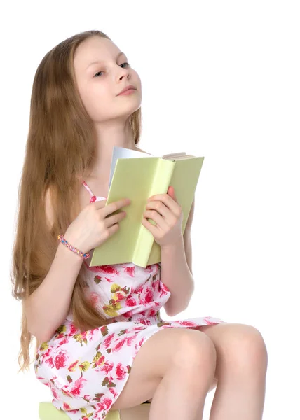 Schoolmeisje zittend op een stapel boeken — Stockfoto