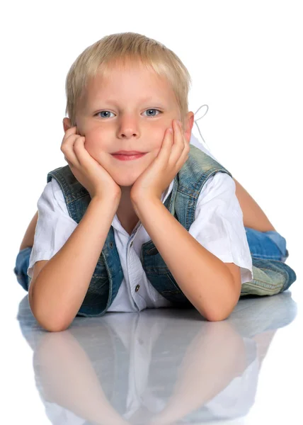 Un niño está tirado en el suelo en el estudio . —  Fotos de Stock