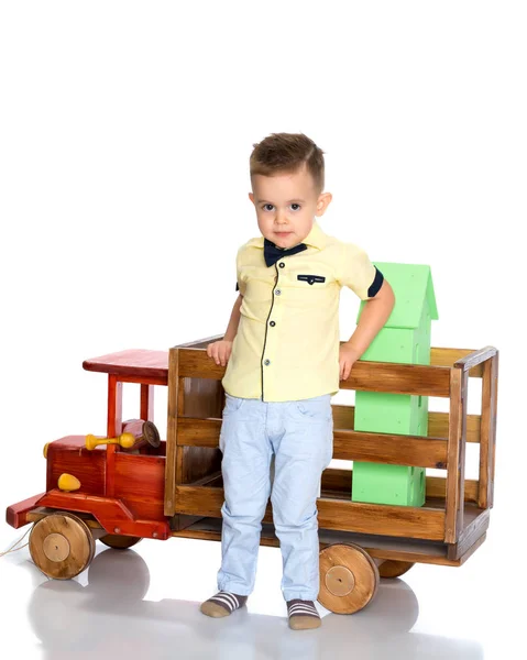 En liten pojke leker med en leksaksbil. — Stockfoto