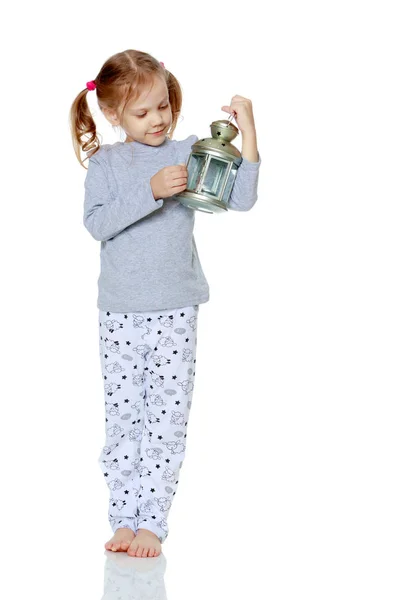 Una niña está sosteniendo una lámpara . — Foto de Stock
