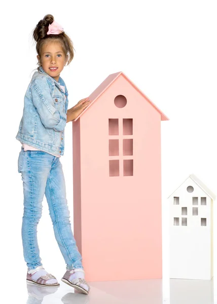 Little girl is playing with wooden houses. — Stock Photo, Image