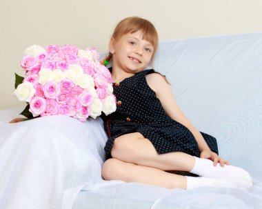 Bir buket çiçek kanepenin üstünde küçük kız