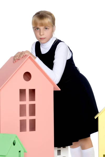 Little girl is playing with wooden houses. — Stock Photo, Image