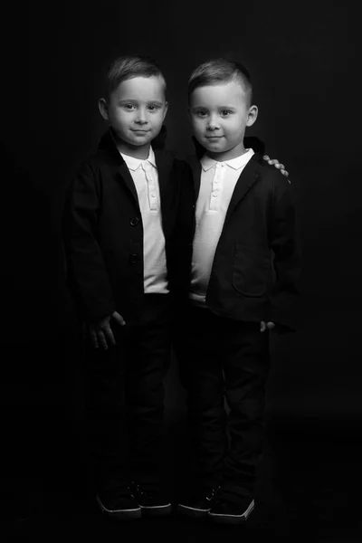 Dois meninos bonitos em ternos pretos — Fotografia de Stock