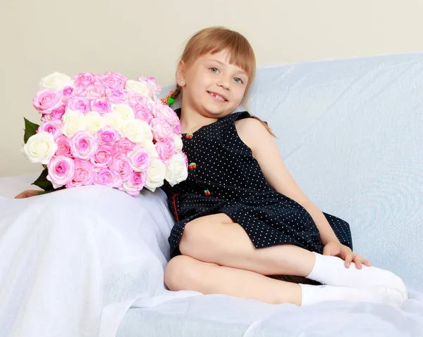 Bir buket çiçek kanepenin üstünde küçük kız