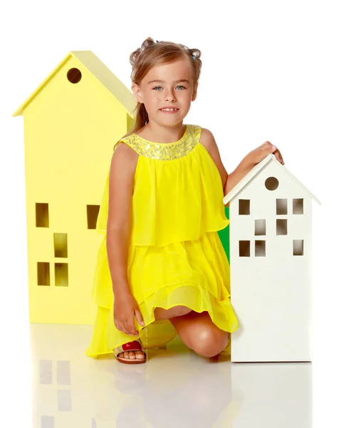 Little girl is playing with wooden houses. — Stock Photo, Image