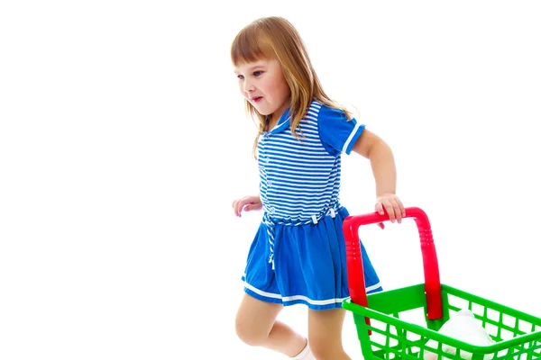 Menina com um carrinho no supermercado . — Fotografia de Stock