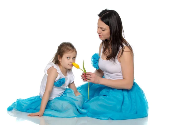 Mãe e filha cheirando tulipas amarelas . — Fotografia de Stock