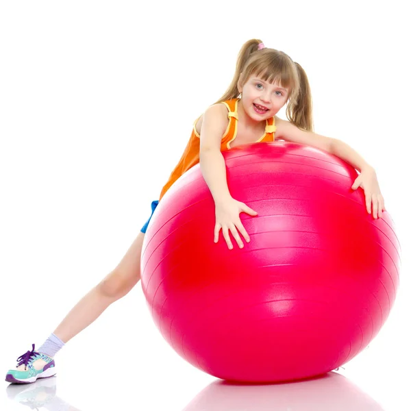 Petite fille faire des exercices sur une grosse balle pour la forme physique. — Photo