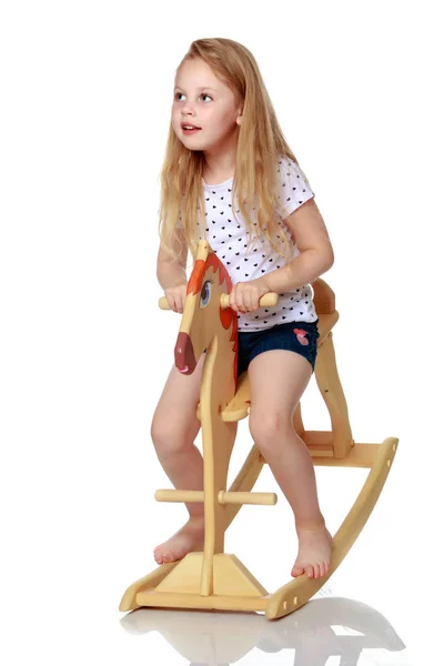 Chica balanceándose en un caballo de madera . —  Fotos de Stock