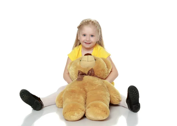 Chica abraza a un gran oso de peluche . —  Fotos de Stock