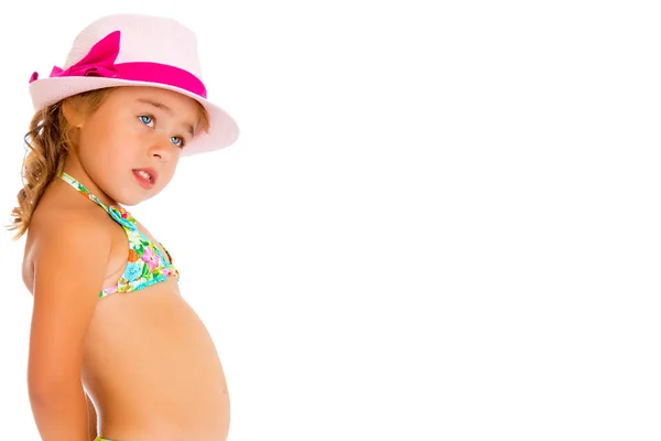 Una pequeña chica bronceada en traje de baño y sombrero . — Foto de Stock