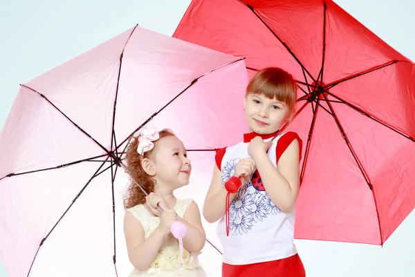 Due ragazze sono sotto gli ombrelli . — Foto Stock