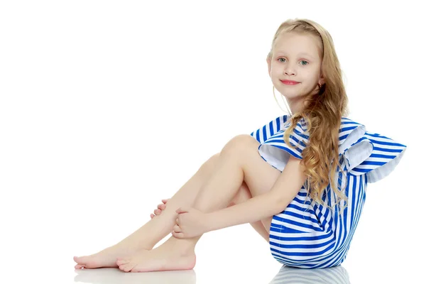 Adorable little blond girl in very short summer striped dress. — Stock Photo, Image