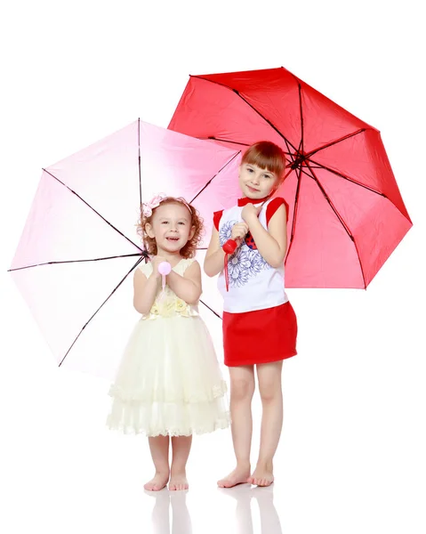 Zwei Mädchen stehen unter Regenschirmen. — Stockfoto