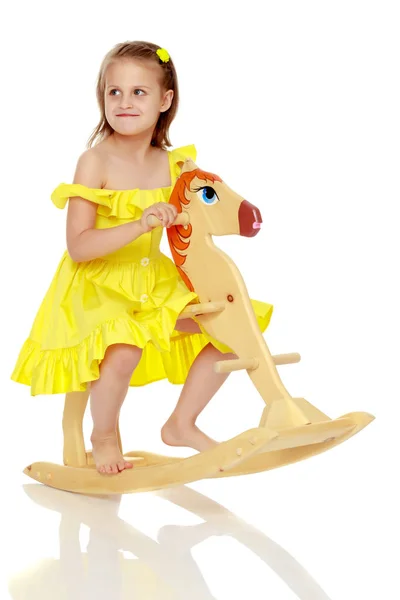 Chica balanceándose en un caballo de madera . — Foto de Stock