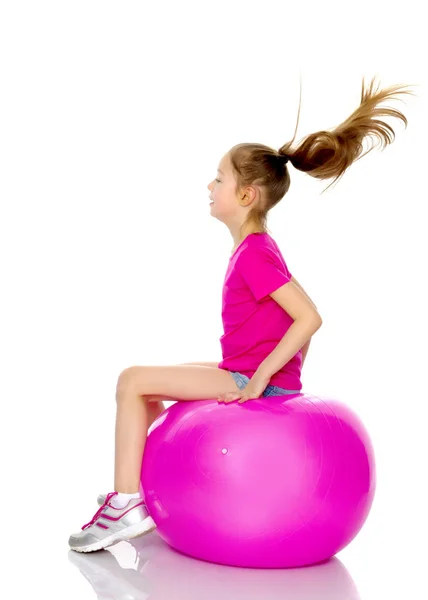 Una bambina sta saltando sulla grande palla palestra . — Foto Stock
