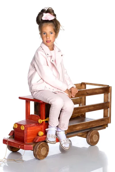 Malá holčička hraje s dřevěné auto. — Stock fotografie