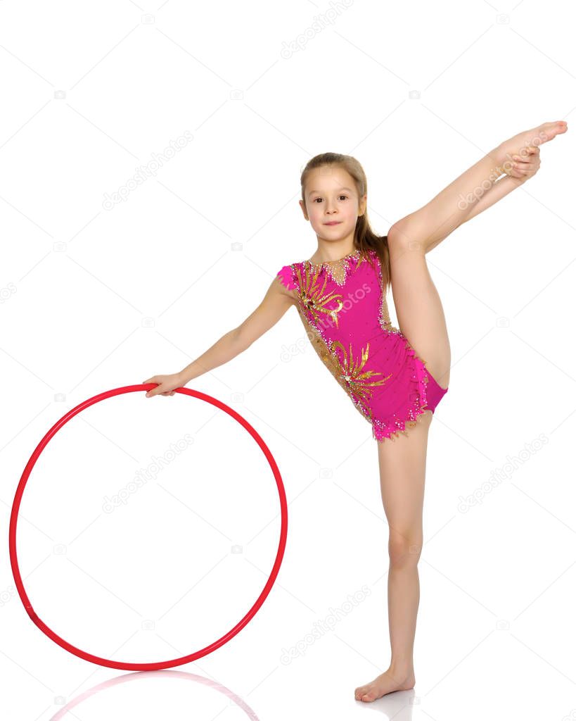 A girl gymnast performs an exercise with a hoop.