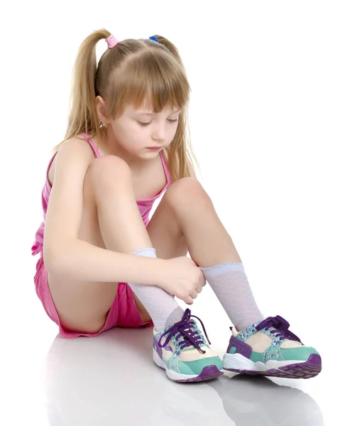 Meisje gymnast zit op de vloer en kreten — Stockfoto