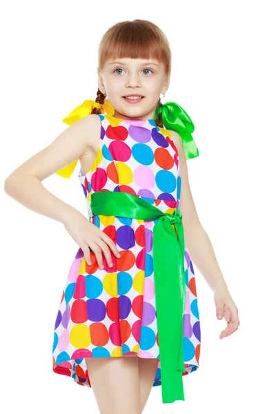 Çok renkli circl üzerinden bir desenli elbise giymiş küçük bir kız — Stok fotoğraf
