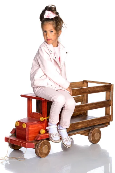 Niña está jugando con un coche de madera . —  Fotos de Stock