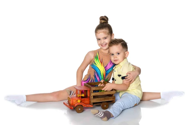 Broer en zus spelen met een speelgoedauto. — Stockfoto