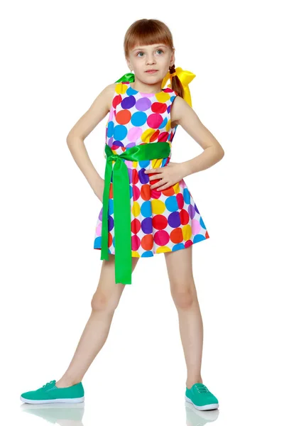 A little girl in a dress with a pattern from multi-colored circl — Stock Photo, Image