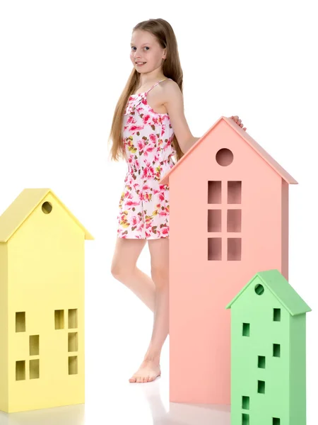 Küçük kız ahşap evler ile oynuyor. — Stok fotoğraf
