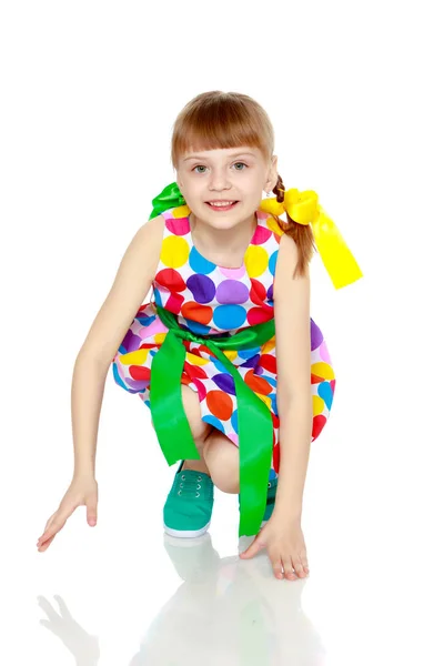 Ei lita jente i kjole med et mønster fra en mangefarget sirkel – stockfoto