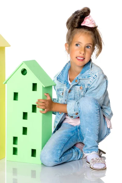 Little girl is playing with wooden houses. — Stock Photo, Image