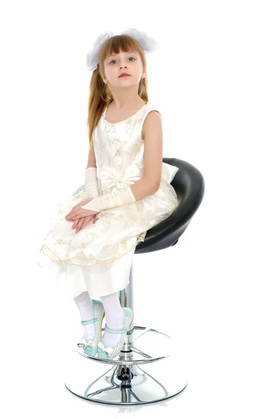 La niña está sentada en una silla. —  Fotos de Stock