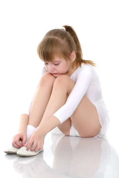 Девушка гимнастка сидит на полу и плачет — стоковое фото
