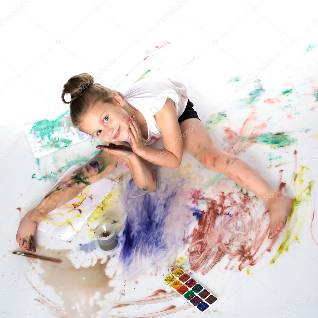 A little girl draws paints on her body