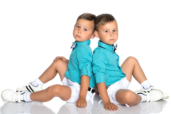 Dois meninos pequenos sentam-se no chão de costas para trás — Fotografia de Stock