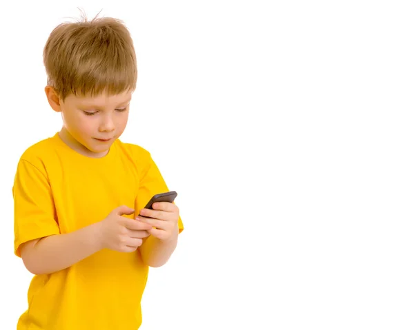 En liten pojke kommunicerar på en mobiltelefon. — Stockfoto